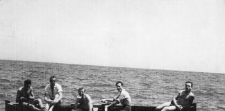 1956. Grup de amics de Can Tunis, donant un fen un tom per la platja en xalana. Proc. Julio Baños